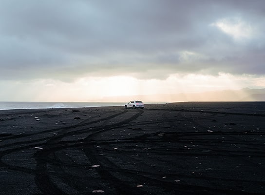 The gray Ionic 5 is stationary in front of the beach.