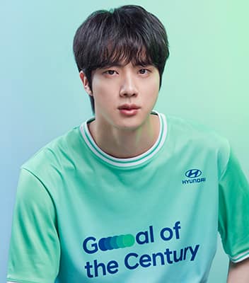 BTS member Jin wearing a green Team Century shirt. 